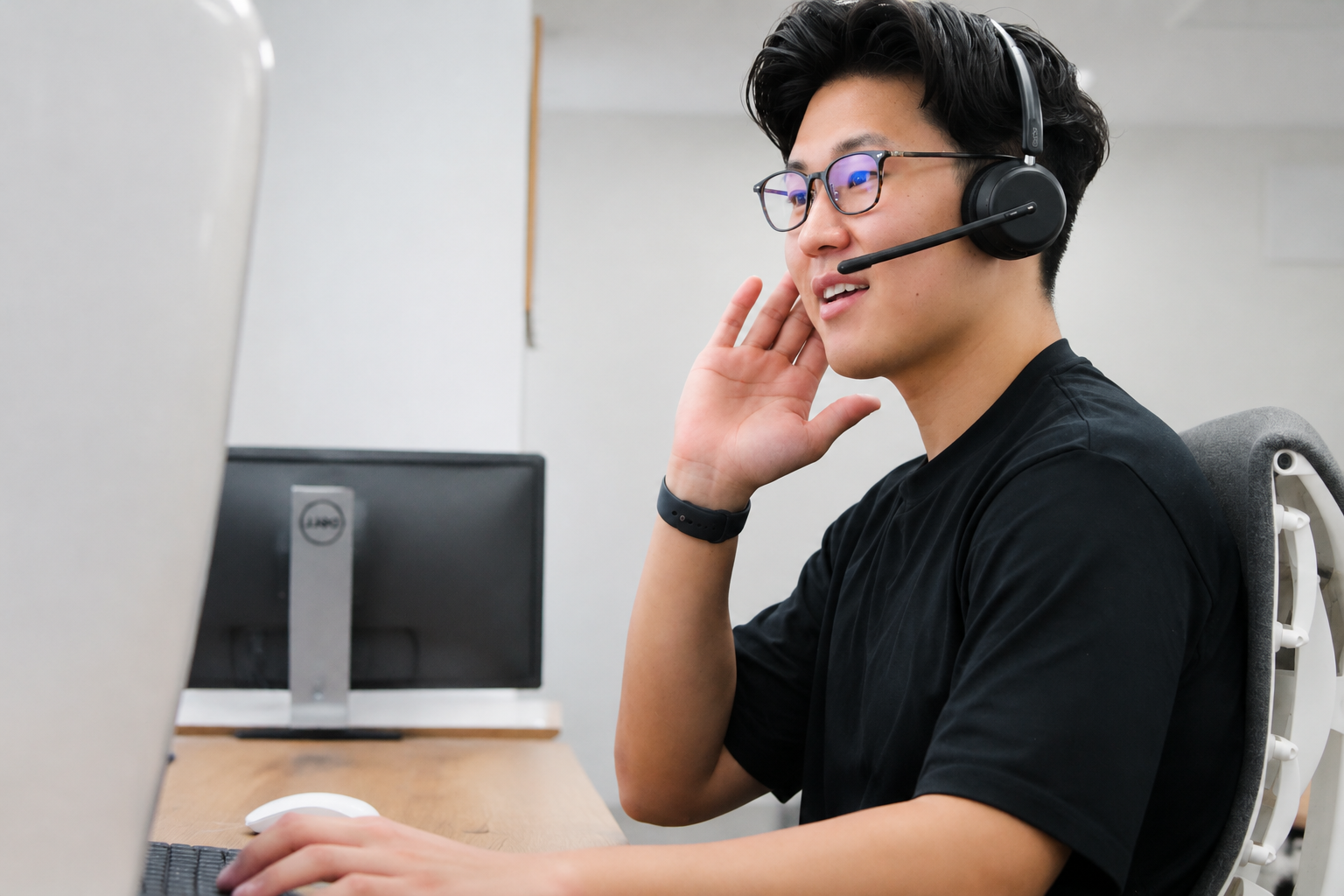 ヘッドセットを着けてPC作業する男性スタッフ